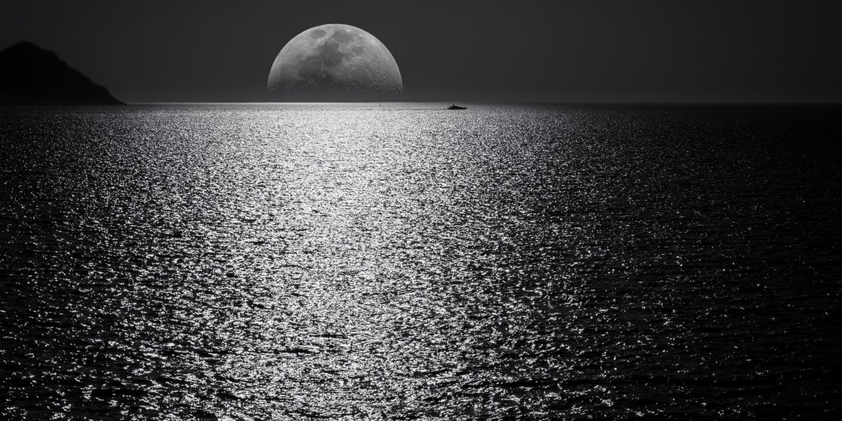 black and white photo of moon on river
